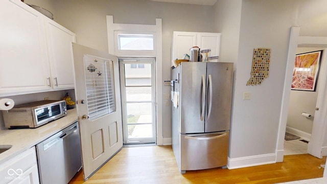 1002 N New Jersey St, Indianapolis, IN 46202 - kitchen with appliances with stainless steel finishes, white cabinets, light wood-type flooring, and plenty of natural light