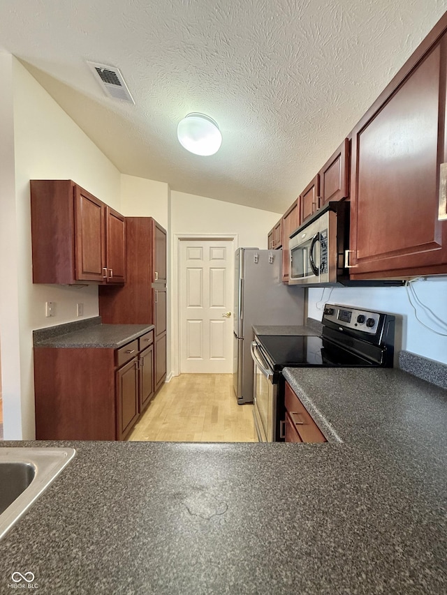 5019 Amber Creek Pl, Indianapolis, IN 46237 - kitchen with stainless steel appliances, dark countertops, light wood-type flooring, and a textured ceiling