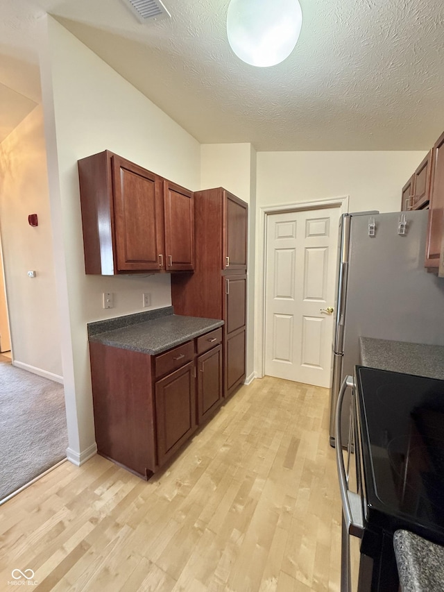 5019 Amber Creek Pl, Indianapolis, IN 46237 - kitchen featuring stainless steel electric range oven, dark countertops, light wood-type flooring, and a textured ceiling