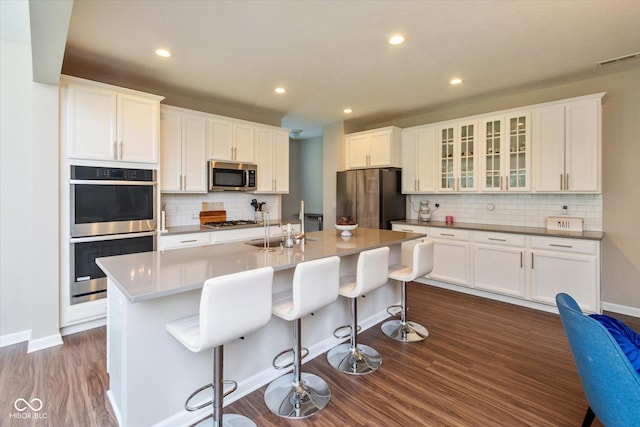 4642 Boyd Pl, Westfield, IN 46062 - kitchen with stainless steel appliances, decorative backsplash, dark wood finished floors, white cabinetry, and glass insert cabinets