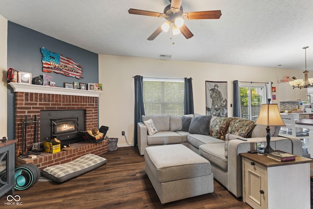 6563 Enclave Blvd, Greenwood, IN 46143 - living area with dark wood-style flooring, ceiling fan, a chandelier, a brick fireplace, and a textured ceiling