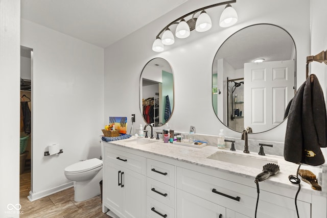 6563 Enclave Blvd, Greenwood, IN 46143 - full bathroom featuring double vanity, a walk in closet, wood finished floors, and an enclosed shower