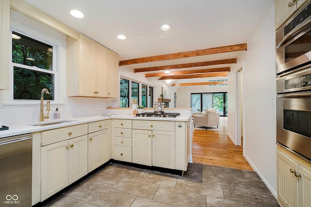 1065 E 76th St, Indianapolis, IN 46240 - kitchen with stainless steel appliances, a peninsula, beam ceiling, light countertops, and recessed lighting