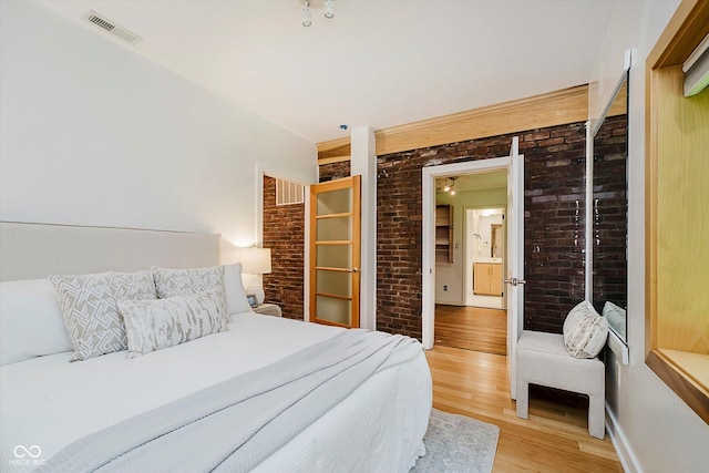 1065 E 76th St, Indianapolis, IN 46240 - bedroom featuring brick wall and light wood-style flooring