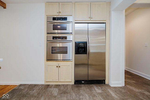 1065 E 76th St, Indianapolis, IN 46240 - kitchen featuring appliances with stainless steel finishes, cream cabinets, and dark wood finished floors