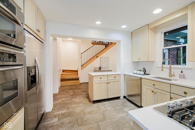 1065 E 76th St, Indianapolis, IN 46240 - kitchen with stainless steel appliances, a peninsula, light countertops, cream cabinetry, and recessed lighting