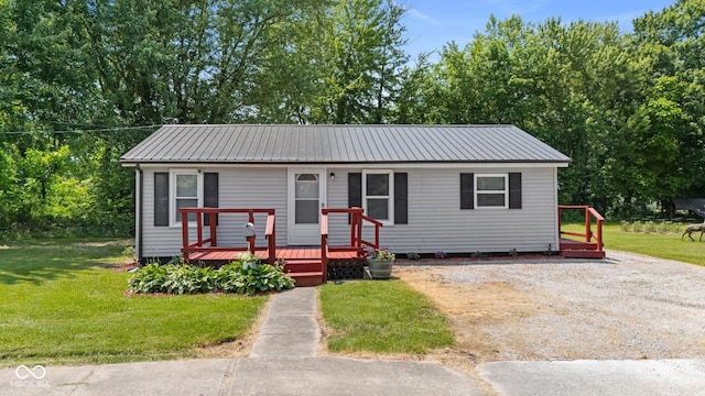 1254 Wade St, Austin, IN 47102 - view of front facade with a front yard, a metal roof, and a wooden deck