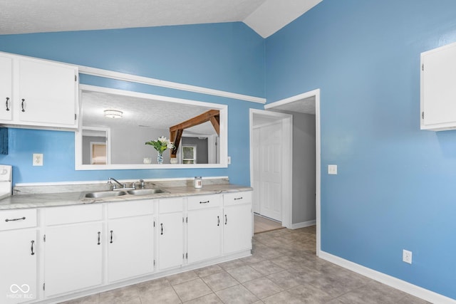 1254 Wade St, Austin, IN 47102 - kitchen featuring vaulted ceiling, white cabinetry, light countertops, a textured ceiling, and light tile patterned floors