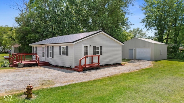 1254 Wade St, Austin, IN 47102 - view of front of house with an outbuilding, a detached garage, a front lawn, gravel driveway, and a metal roof