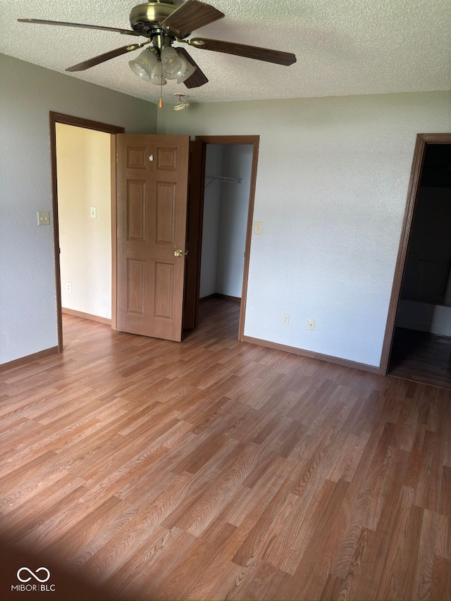 39 Meadow Creek E Boulevard, Whiteland, IN 46184 - unfurnished bedroom featuring light wood-type flooring, a spacious closet, a closet, a textured ceiling, and ceiling fan