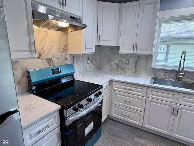1818 Broadway St, Anderson, IN 46012 - kitchen with appliances with stainless steel finishes, under cabinet range hood, white cabinets, and tasteful backsplash