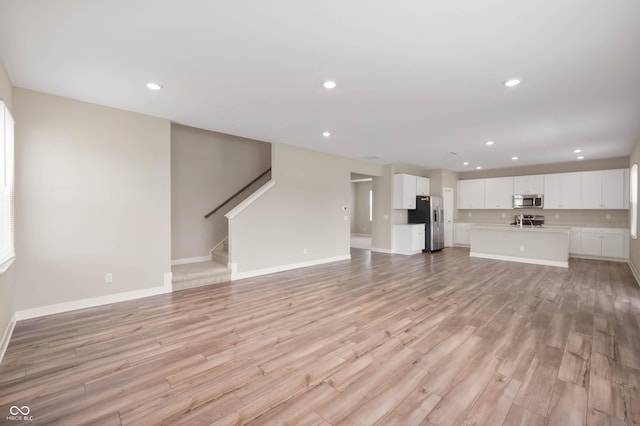 7510 Hillway Dr, Camby, IN 46113 - unfurnished living room featuring recessed lighting, light wood-style floors, and stairs