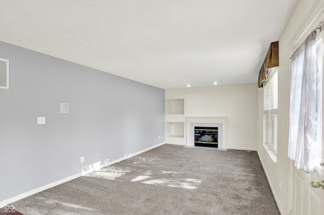 11961 Driftstone Dr, Fishers, IN 46037 - unfurnished living room with carpet floors, a tile fireplace, and built in shelves