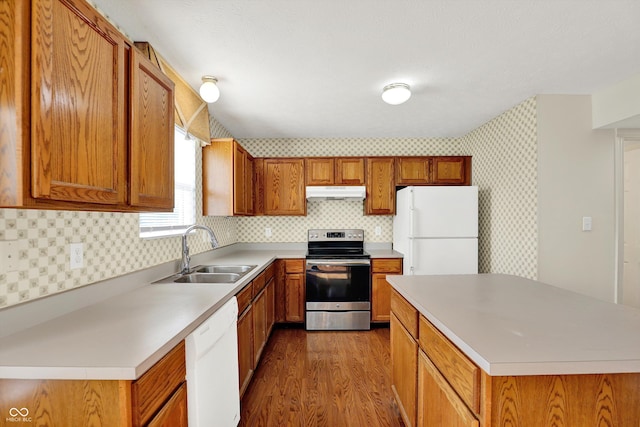 11961 Driftstone Dr, Fishers, IN 46037 - kitchen featuring white appliances, under cabinet range hood, dark wood-type flooring, light countertops, and brown cabinetry