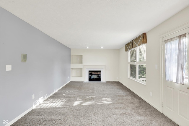 11961 Driftstone Dr, Fishers, IN 46037 - unfurnished living room with carpet, a fireplace with flush hearth, and built in shelves