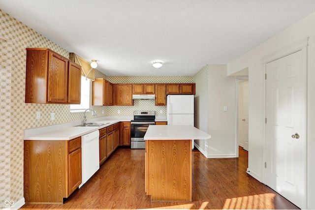 11961 Driftstone Dr, Fishers, IN 46037 - kitchen with white appliances, under cabinet range hood, wallpapered walls, light countertops, and a kitchen island