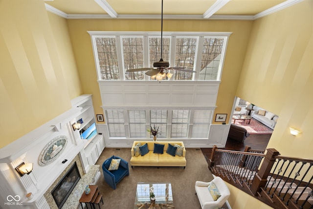 1130 Kingswood Rd S, West Lafayette, IN 47906 - living room with a glass covered fireplace, a ceiling fan, a high ceiling, ornamental molding, and wood finished floors