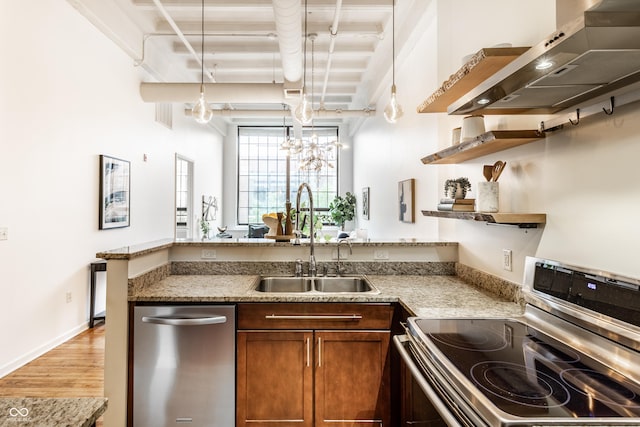 624 E Walnut St Unit 48, Indianapolis, IN 46204 - kitchen featuring appliances with stainless steel finishes, wall chimney exhaust hood, open shelves, a peninsula, and light wood-style flooring