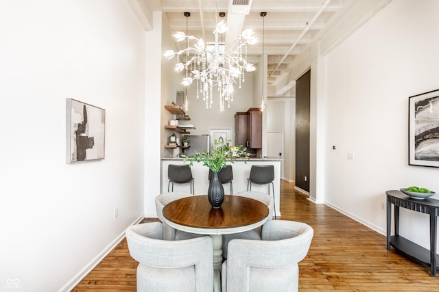624 E Walnut St Unit 48, Indianapolis, IN 46204 - dining area with a chandelier, wood finished floors, a towering ceiling, and beamed ceiling