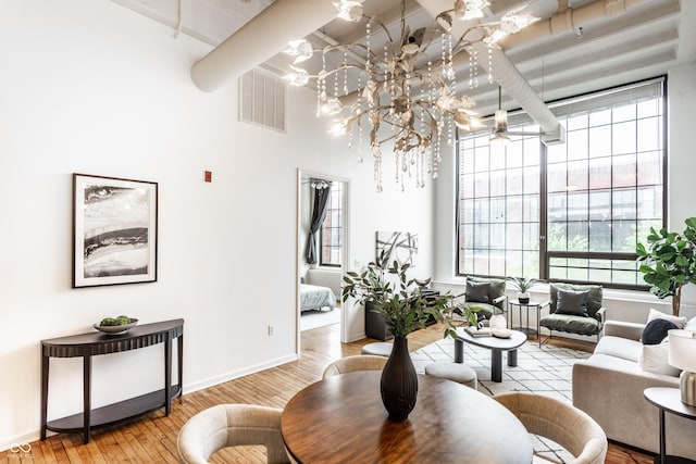 624 E Walnut St Unit 48, Indianapolis, IN 46204 - living area with wood finished floors, a chandelier, healthy amount of natural light, beamed ceiling, and a high ceiling