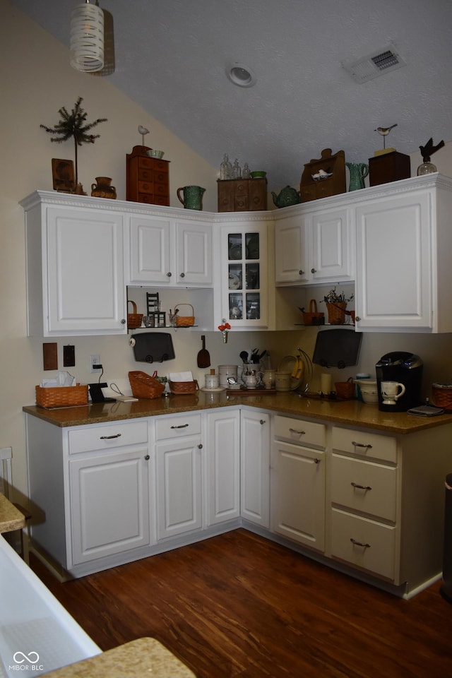 7357 Lake Lakota Dr, Indianapolis, IN 46217 - kitchen with white cabinetry, dark wood-style flooring, lofted ceiling, and glass insert cabinets