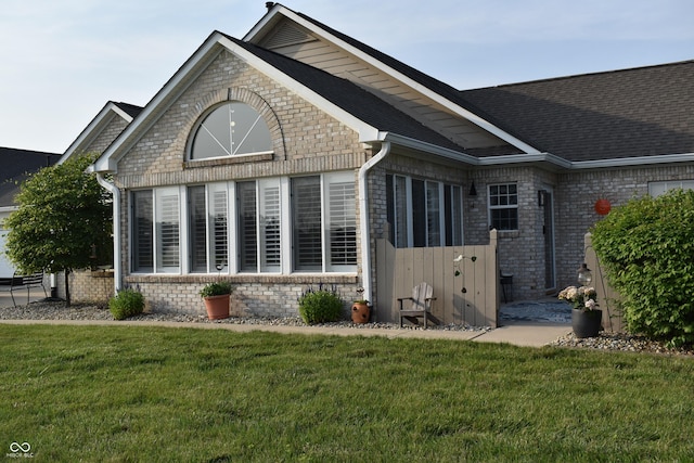 7357 Lake Lakota Dr, Indianapolis, IN 46217 - view of front of house with brick siding, a front yard, and a shingled roof