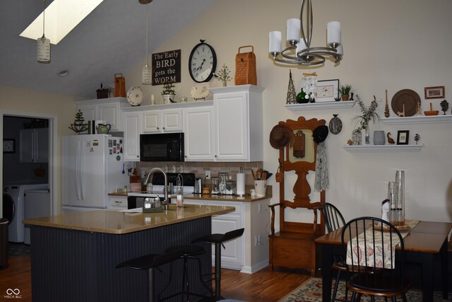 7357 Lake Lakota Dr, Indianapolis, IN 46217 - kitchen featuring black microwave, freestanding refrigerator, dark wood-style floors, tasteful backsplash, and a skylight