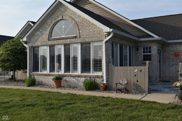 7357 Lake Lakota Dr, Indianapolis, IN 46217 - view of home's exterior with brick siding, a yard, and roof with shingles