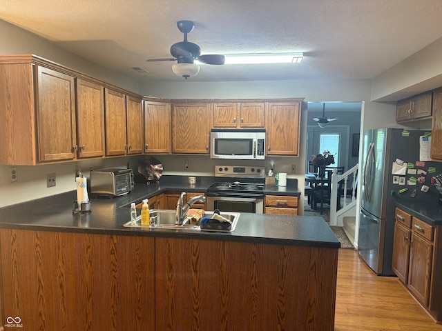 11632 Coastal Way, Indianapolis, IN 46229 - kitchen featuring appliances with stainless steel finishes, ceiling fan, a peninsula, dark countertops, and a textured ceiling