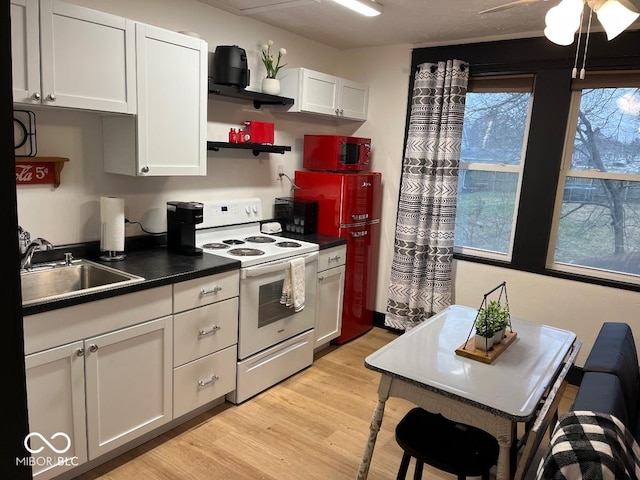 251 N St, Danville, IN 46122 - kitchen with electric stove, white cabinets, light wood-style flooring, dark countertops, and open shelves