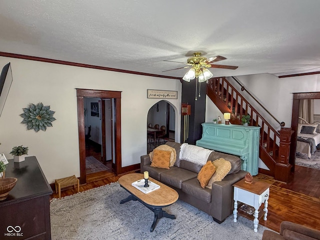 251 N St, Danville, IN 46122 - living room featuring arched walkways, ceiling fan, stairs, wood finished floors, and ornamental molding