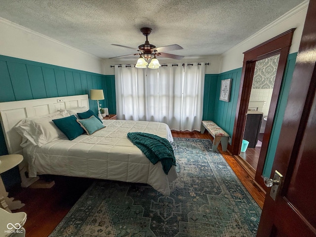 251 N St, Danville, IN 46122 - bedroom with wood finished floors, ornamental molding, a textured ceiling, wainscoting, and a ceiling fan
