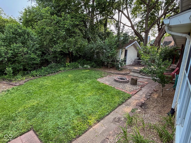 251 N St, Danville, IN 46122 - view of green lawn featuring a fire pit, a patio area, and an outbuilding
