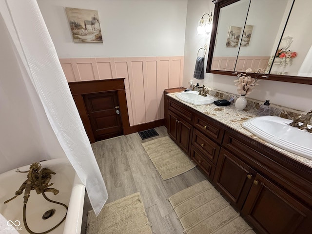 251 N St, Danville, IN 46122 - bathroom with double vanity, wood finished floors, and a tub to relax in