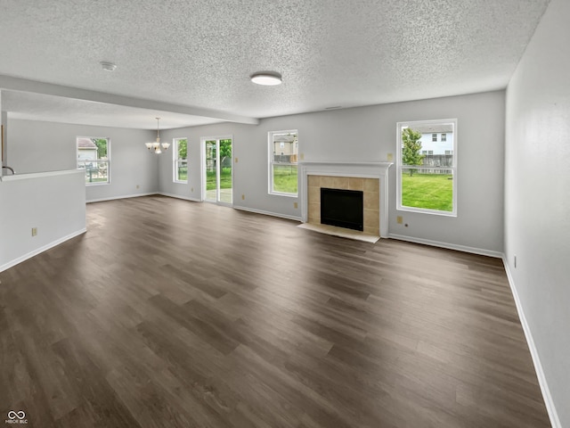 3445 Brandenburg Blvd, Indianapolis, IN 46239 - unfurnished living room featuring a chandelier, a textured ceiling, dark wood-type flooring, and a tile fireplace