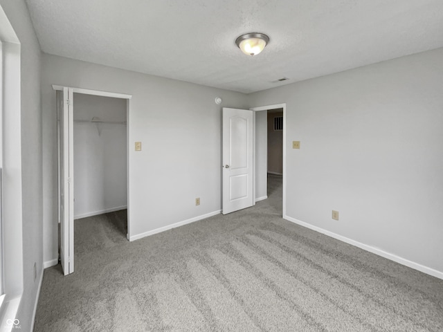 3445 Brandenburg Blvd, Indianapolis, IN 46239 - unfurnished bedroom with carpet floors, a spacious closet, a textured ceiling, and a closet