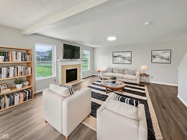 3445 Brandenburg Blvd, Indianapolis, IN 46239 - living room featuring wood finished floors, beamed ceiling, a fireplace, and a textured ceiling