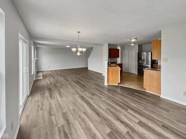 3445 Brandenburg Blvd, Indianapolis, IN 46239 - unfurnished living room featuring a textured ceiling, a chandelier, and dark wood finished floors