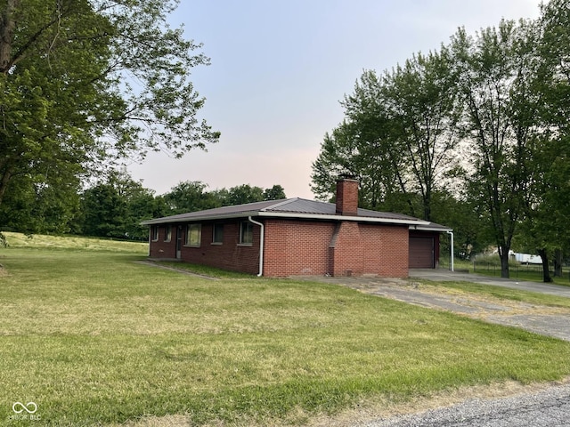 406 N Main St, Cloverdale, IN 46120 - view of side of property with asphalt driveway, a garage, a lawn, a chimney, and brick siding