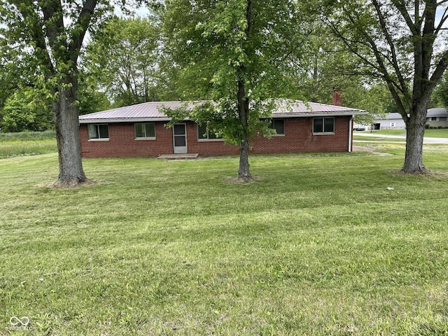 406 N Main St, Cloverdale, IN 46120 - view of front of property with brick siding, a front yard, a metal roof, and a chimney