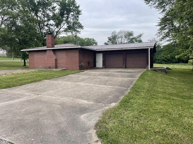 406 N Main St, Cloverdale, IN 46120 - view of front facade with a front lawn, a chimney, concrete driveway, a garage, and a metal roof