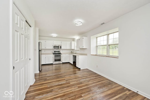 11320 Lynchburg Way, Indianapolis, IN 46229 - kitchen featuring stainless steel appliances, light countertops, dark wood-type flooring, and white cabinetry