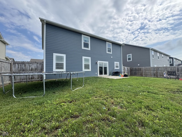8969 Faulkner Dr, Indianapolis, IN 46239 - back of house featuring a fenced backyard, a patio area, and a trampoline
