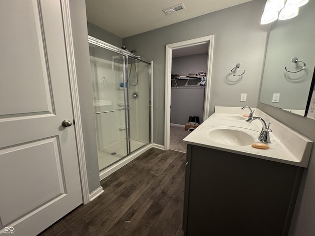 8969 Faulkner Dr, Indianapolis, IN 46239 - bathroom featuring a shower stall, wood finished floors, double vanity, and a walk in closet
