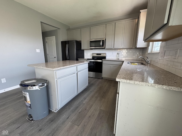8969 Faulkner Dr, Indianapolis, IN 46239 - kitchen with stainless steel appliances, dark wood-style flooring, backsplash, a center island, and light stone counters