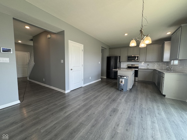 8969 Faulkner Dr, Indianapolis, IN 46239 - kitchen featuring appliances with stainless steel finishes, gray cabinetry, dark wood finished floors, a kitchen island, and recessed lighting