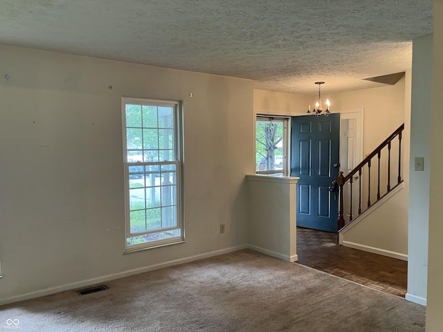 7667 Madden Ln, Fishers, IN 46038 - foyer entrance featuring a chandelier, healthy amount of natural light, carpet floors, stairs, and a textured ceiling