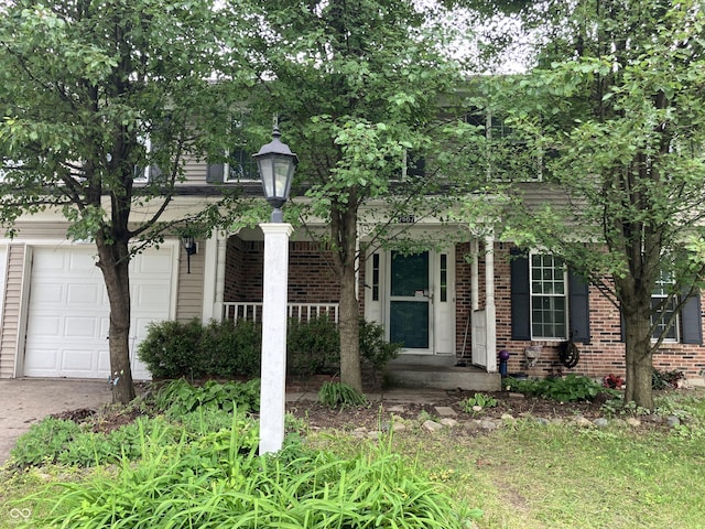7667 Madden Ln, Fishers, IN 46038 - obstructed view of property featuring brick siding, an attached garage, and concrete driveway