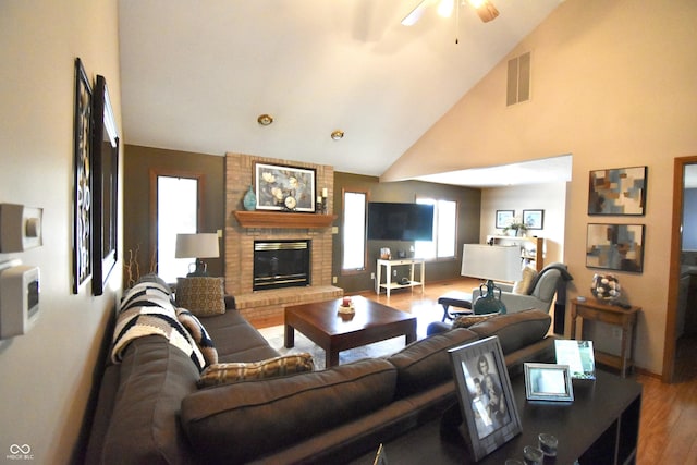 5943 Red Maple Dr, Indianapolis, IN 46237 - living room featuring wood finished floors, ceiling fan, high vaulted ceiling, and a brick fireplace