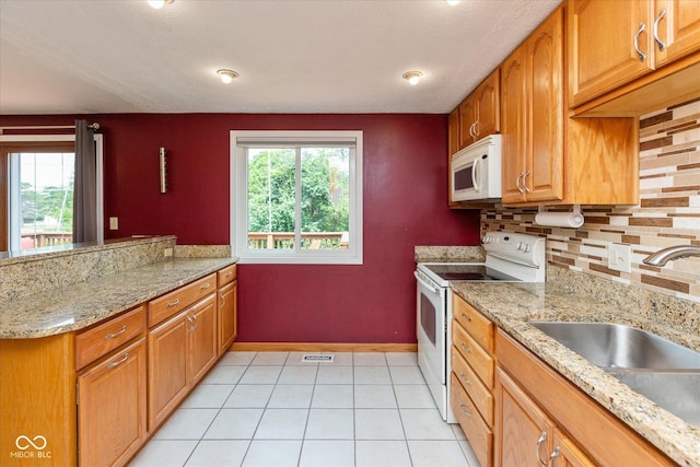 5802 Rymark Ct, Indianapolis, IN 46250 - kitchen featuring white appliances, healthy amount of natural light, decorative backsplash, and light tile patterned floors